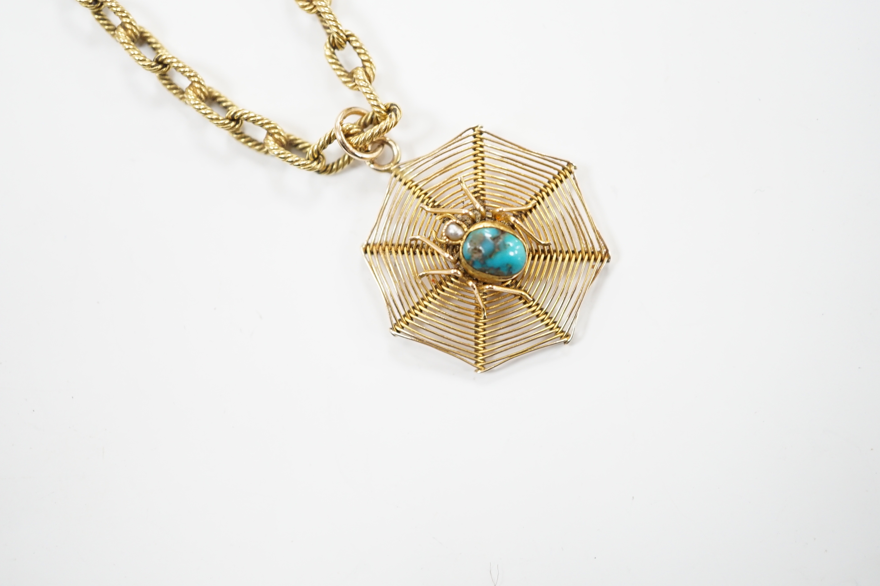 An early 20th century 9ct, turquoise and seed pearl set 'spider and web' pendant, 30mm, on a yellow metal chain, stamped 18 and numbered 2312, one link bearing the engraved word 'Cartier', 58cm, gross weight 23.2 grams.